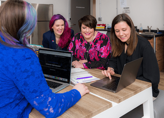 A group of women colleagues checking out the AceUp solution on their laptops.